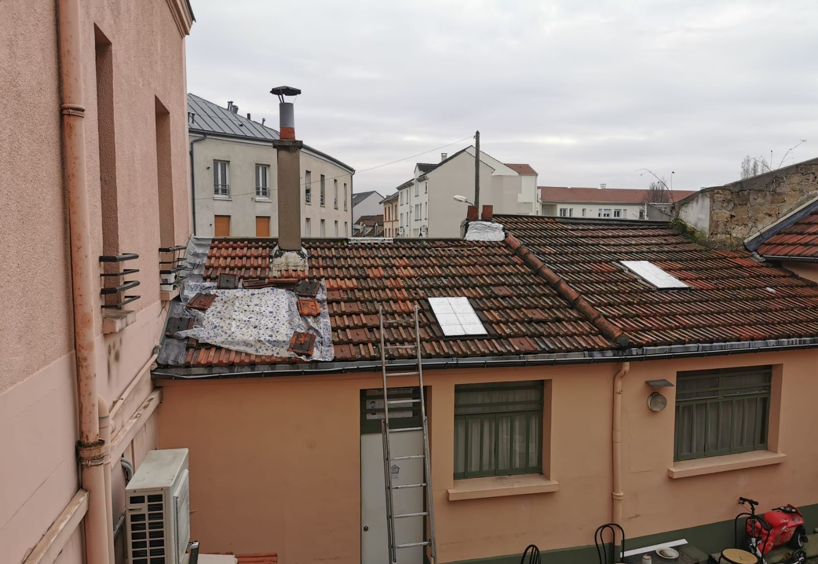 Chantier de rénovation de couverture presque terminé sous un ciel gris