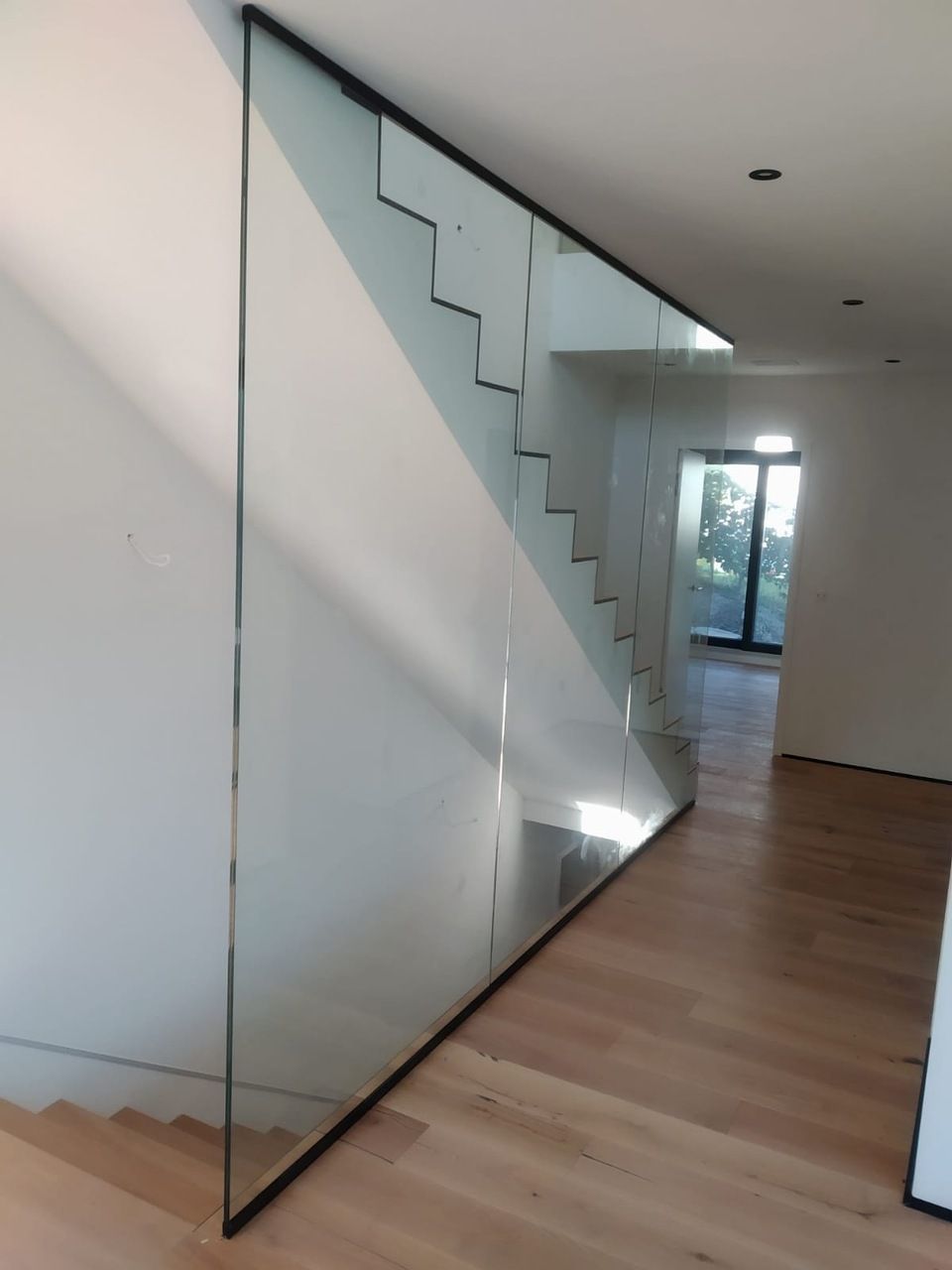 escalier blanc et mur en verre