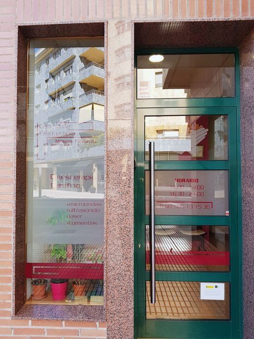 Un edificio de ladrillo con una puerta verde y una ventana.