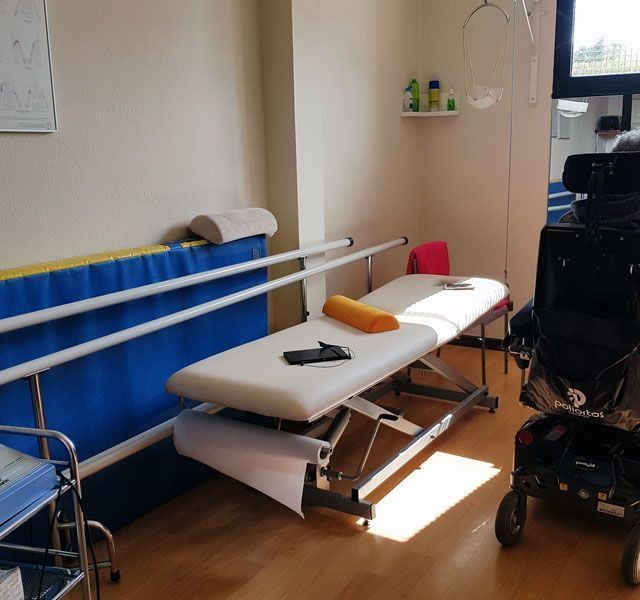 Una habitación de hospital con una cama y una silla de ruedas