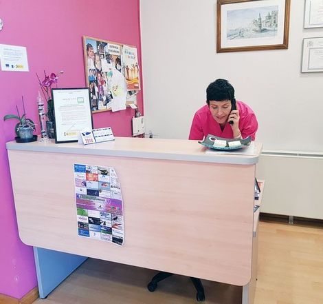 Una mujer sentada en un escritorio hablando por un teléfono celular