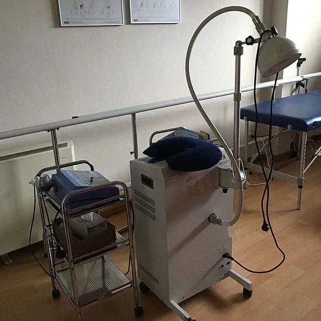 Una máquina con una manguera conectada a ella está en una habitación al lado de una mesa.