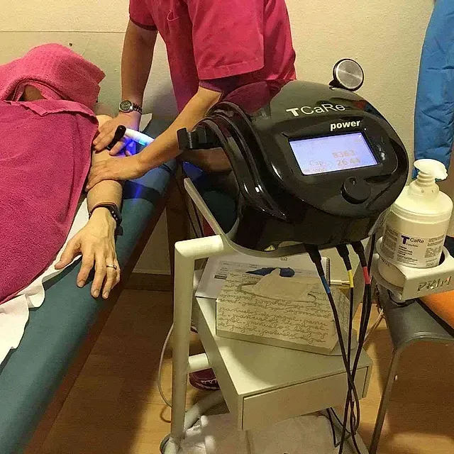 Una mujer está recibiendo un masaje con una máquina que dice