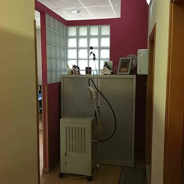 Una habitación con una pared rosa y un armario blanco.