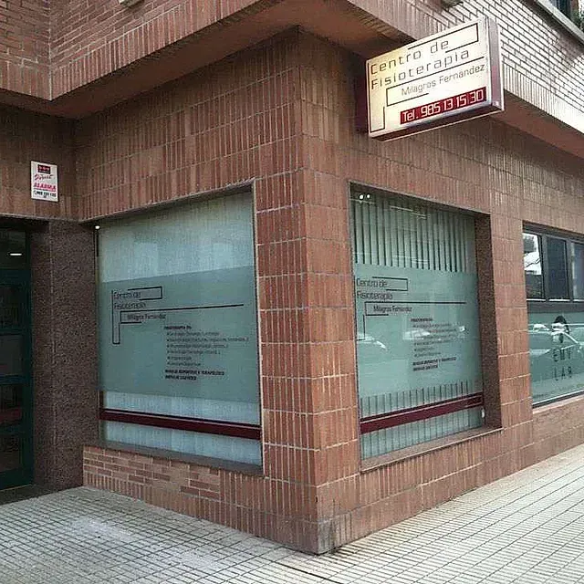 Un edificio de ladrillo con un cartel al costado que dice centro de fisioterapia.