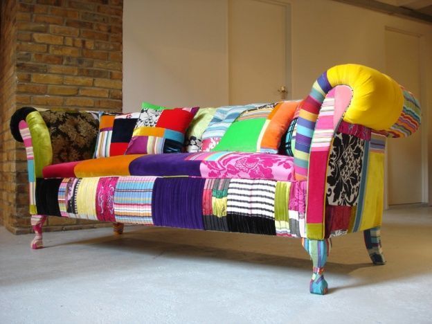 Sofá colorido em patchwork em um ambiente interno; diversas texturas e tonalidades de tecido.