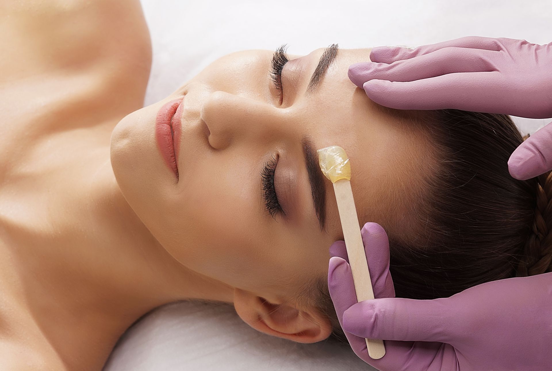 Une cliente se fait épiler le haut du sourcil