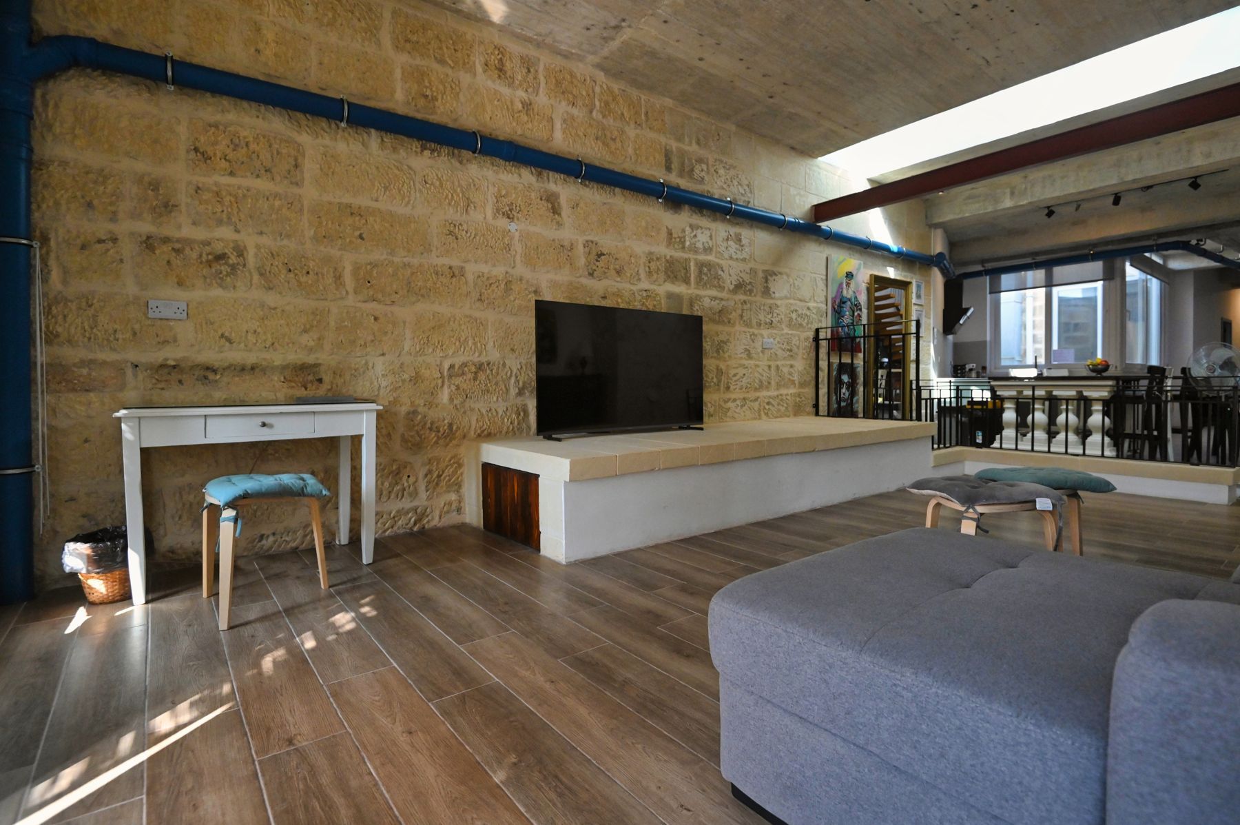 Living room with exposed stone wall at Silver Jubilee House, Xagħra, Gozo