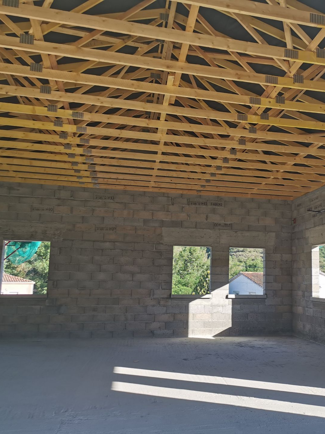 Intérieur d'un bâtiment en construction. Chevrons en bois et murs en parpaings.