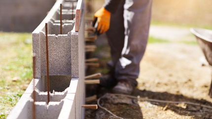 Un maçon qui fait un mur en agglo.