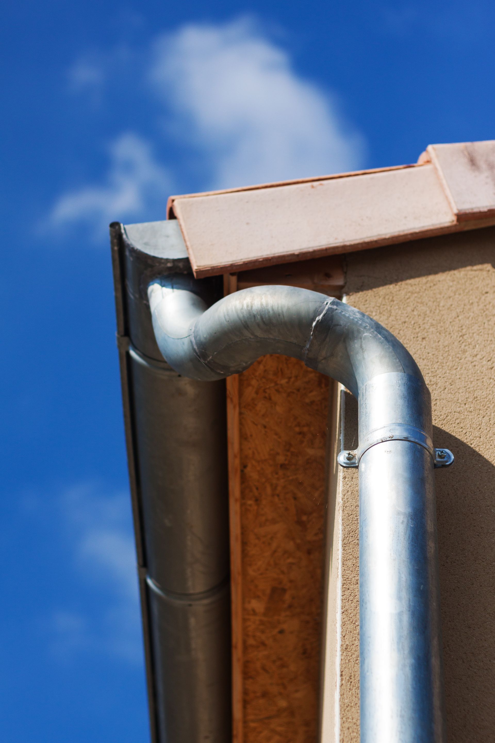 Gouttière et tuyau en métal sur un bâtiment.