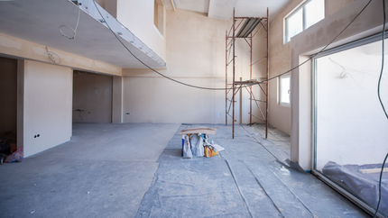Intérieur d'un bâtiment en construction. Murs bruts, sol en béton avec un échafaudage.