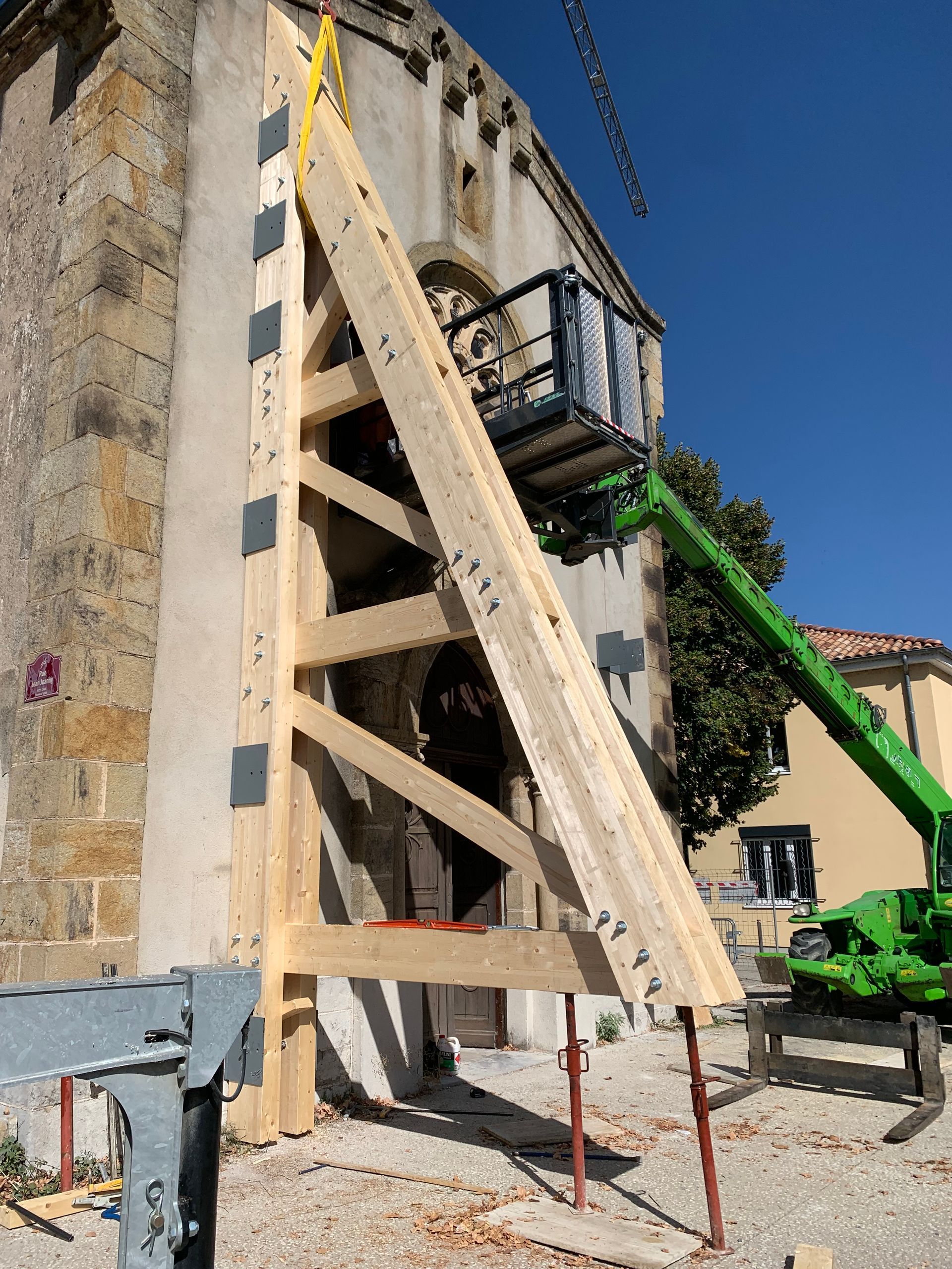 Installation d'un renfort en bois pour soutenir un mur d'église pendant la construction.