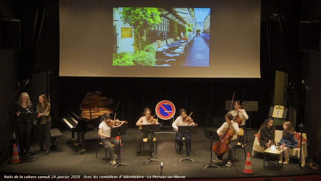 Un ensemble à cordes se produit sur scène. Un écran diffuse une scène de rue.