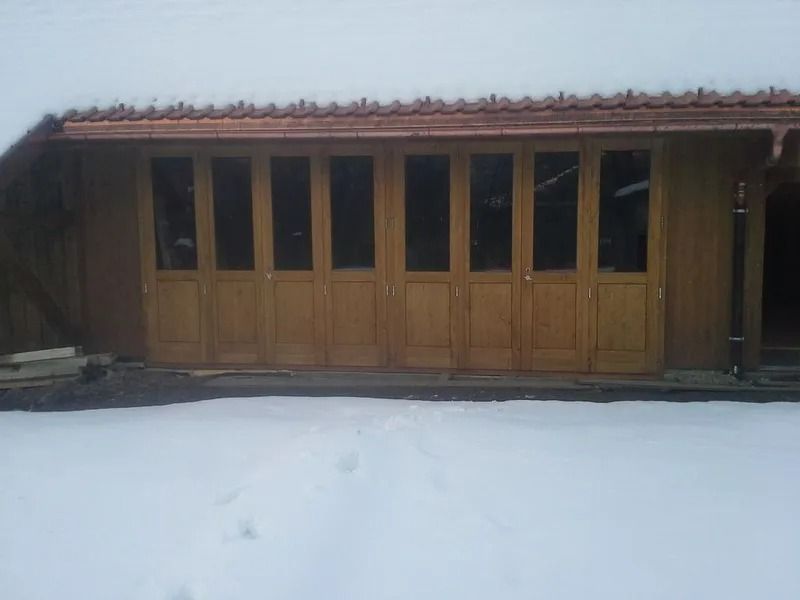 Bâtiment en bois avec des fenêtres en verre dans un décor extérieur enneigé