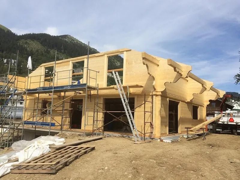 Maison partiellement construite, à ossature bois, avec échafaudages et échelles sur un chantier de construction