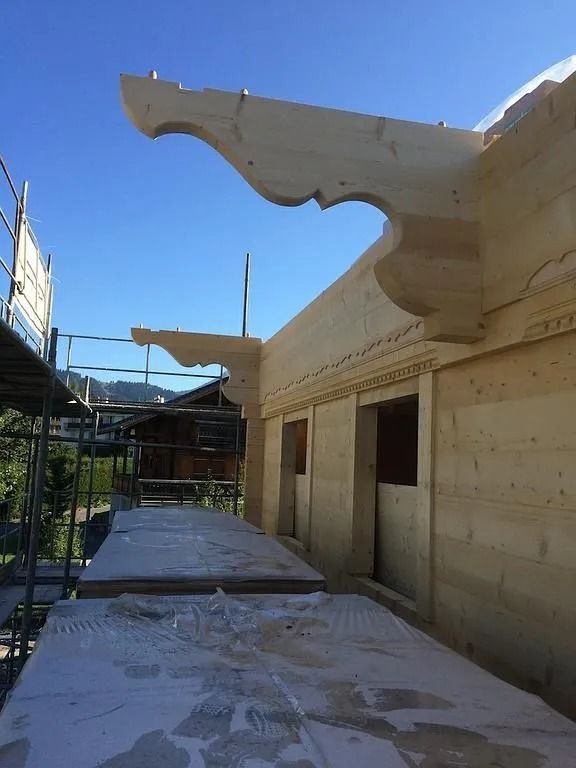 Bâtiment en bord de mer avec un grand toit sculptural blanc sous un ciel bleu clair
