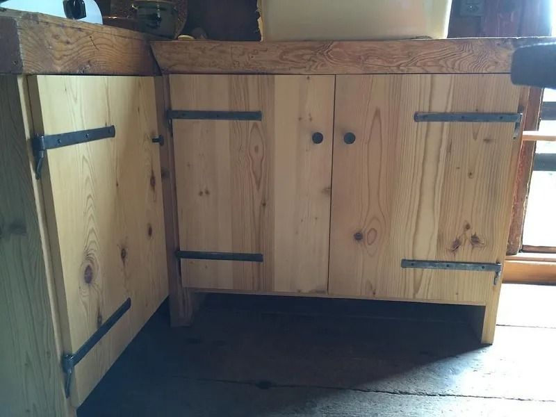 Meuble sous comptoir en bois avec charnières noires et doubles portes dans un espace de type cuisine
