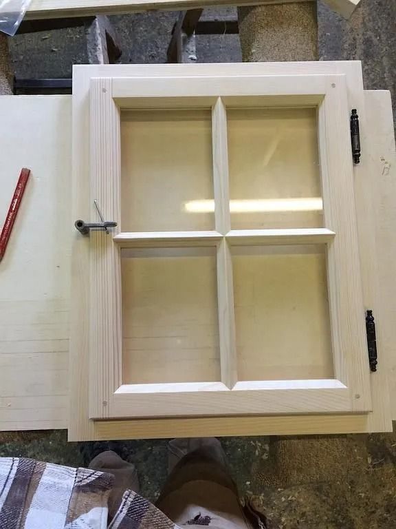 Cadre de fenêtre en bois blanc à quatre vitres, posé au sol lors de l'installation ou de la réparation