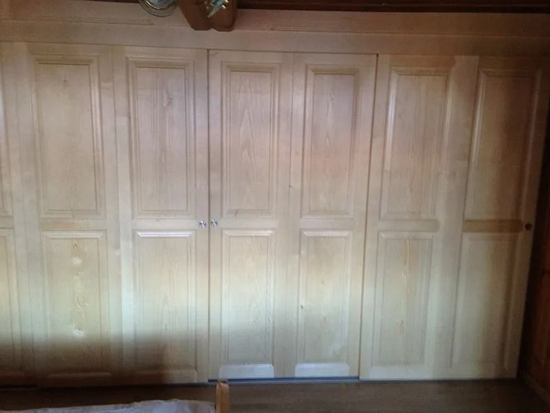 Portes de placard à panneaux de bois encastrés et plancher en bois en dessous.