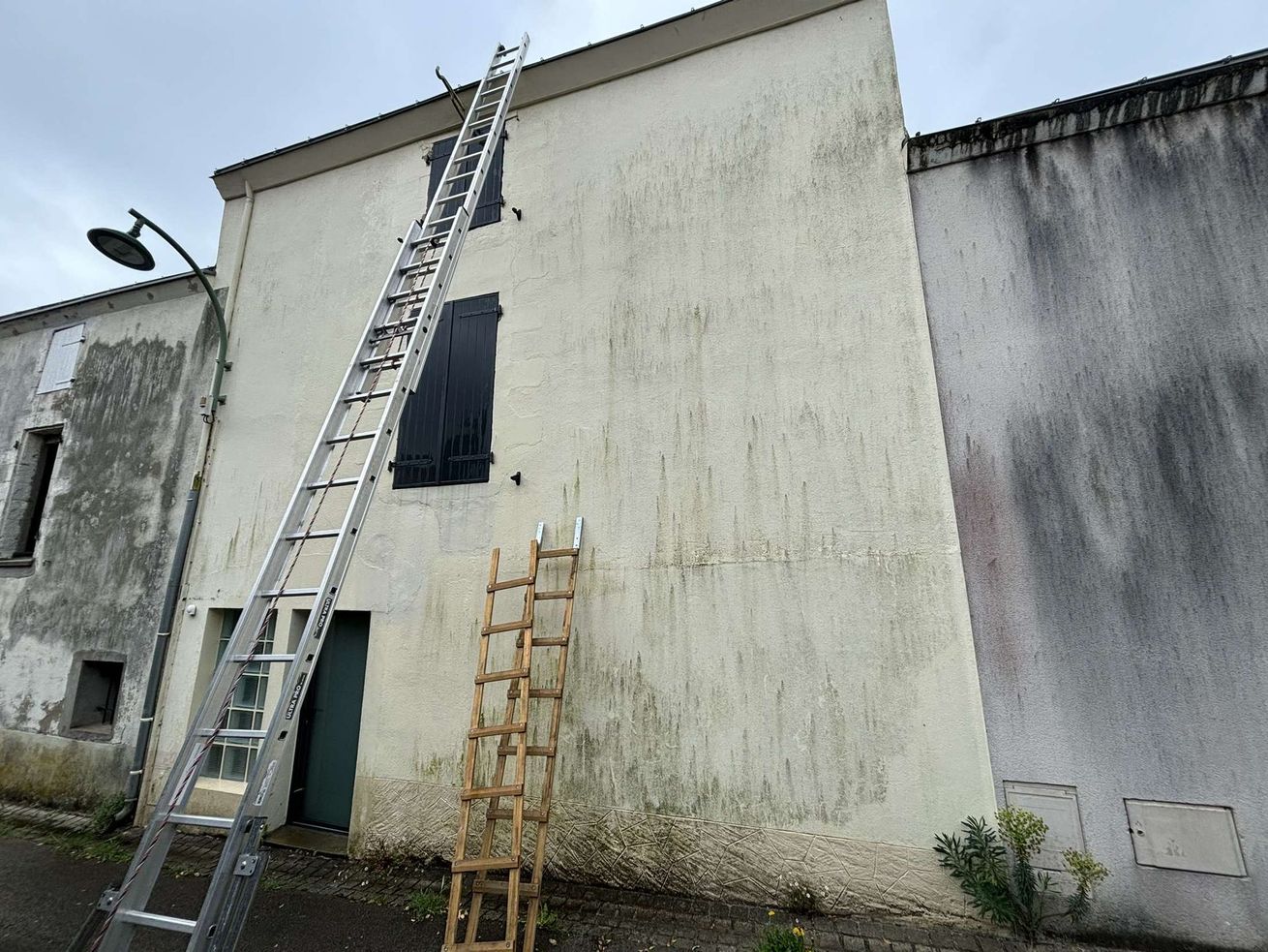 Échelles posées sur une façade de maison sale