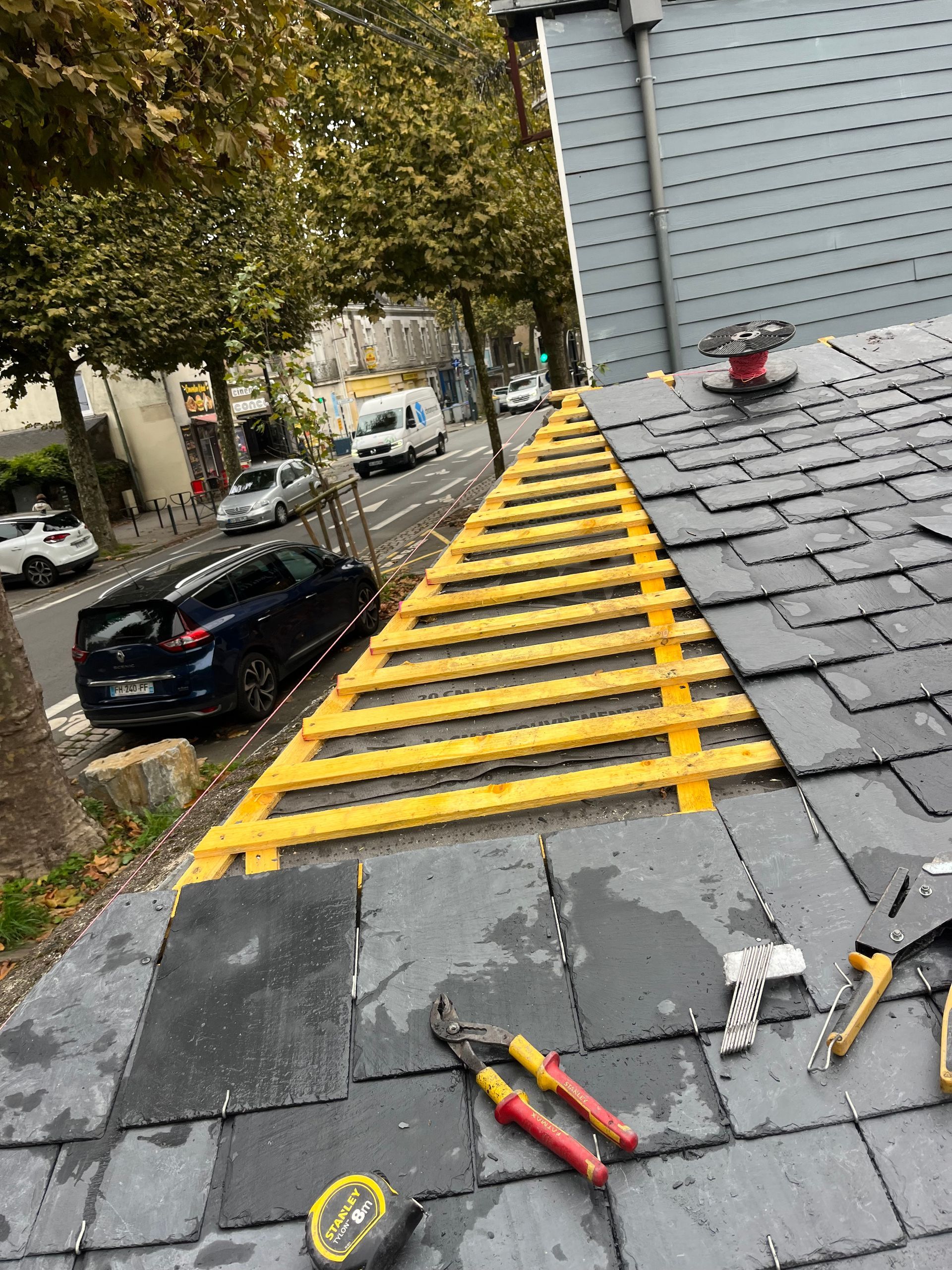 Outils sur une toiture en ardoise en cours de construction