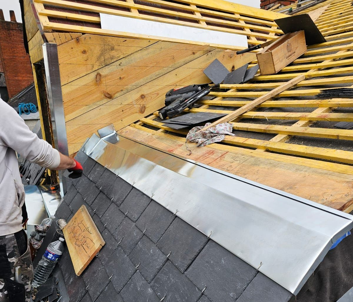 Ouvrier ajustant la zinguerie d'une toiture en ardoise