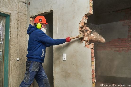 Bauarbeiter reißt Mauer ein