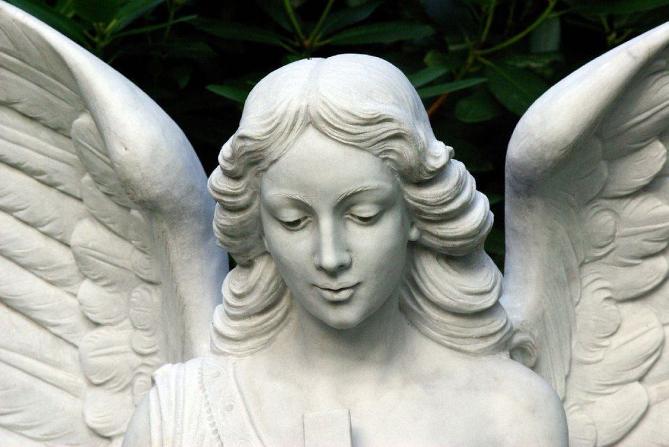 Un gros plan d'une statue d'un ange avec les yeux fermés