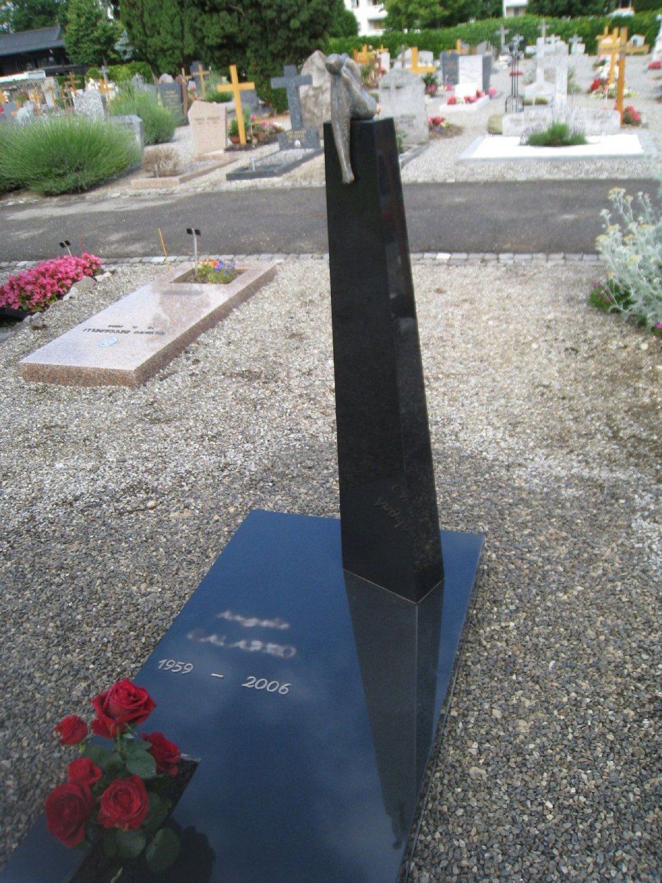 Une tombe dans un cimetière avec une statue au sommet