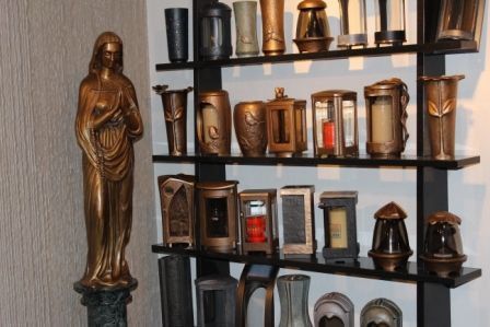 Une étagère pleine de vases et une statue de Jésus