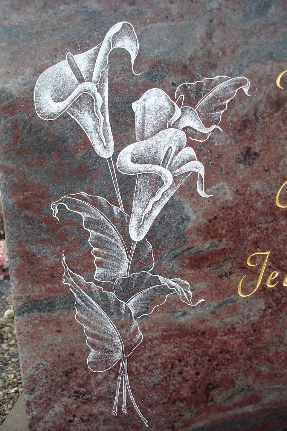 Une pierre tombale avec un dessin de fleurs dessus.