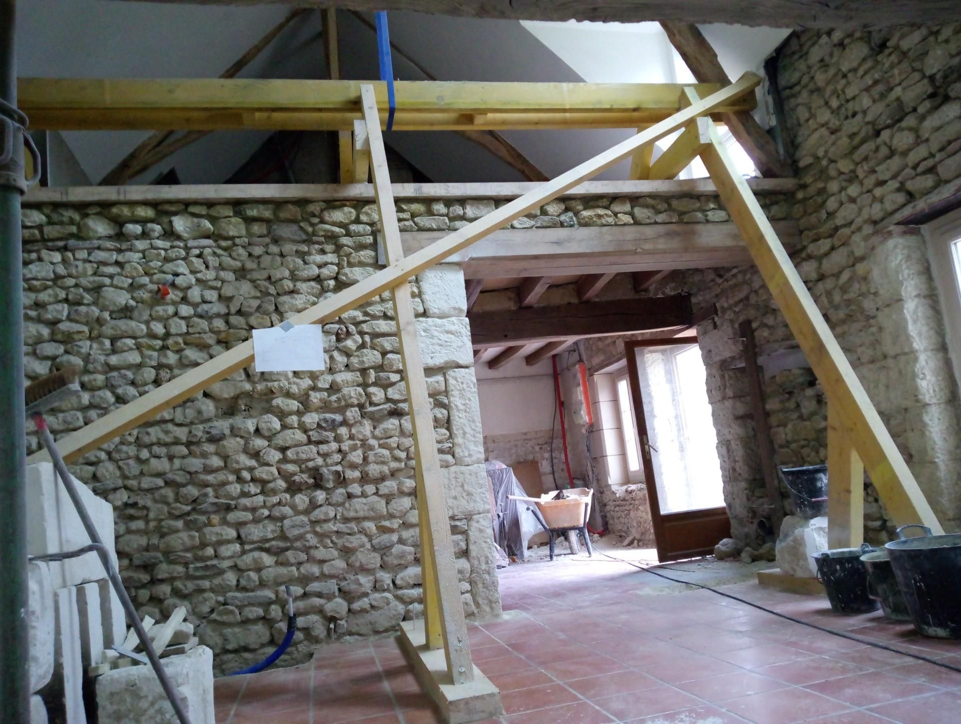 Intérieur en travaux, murs en pierre, charpente en bois.