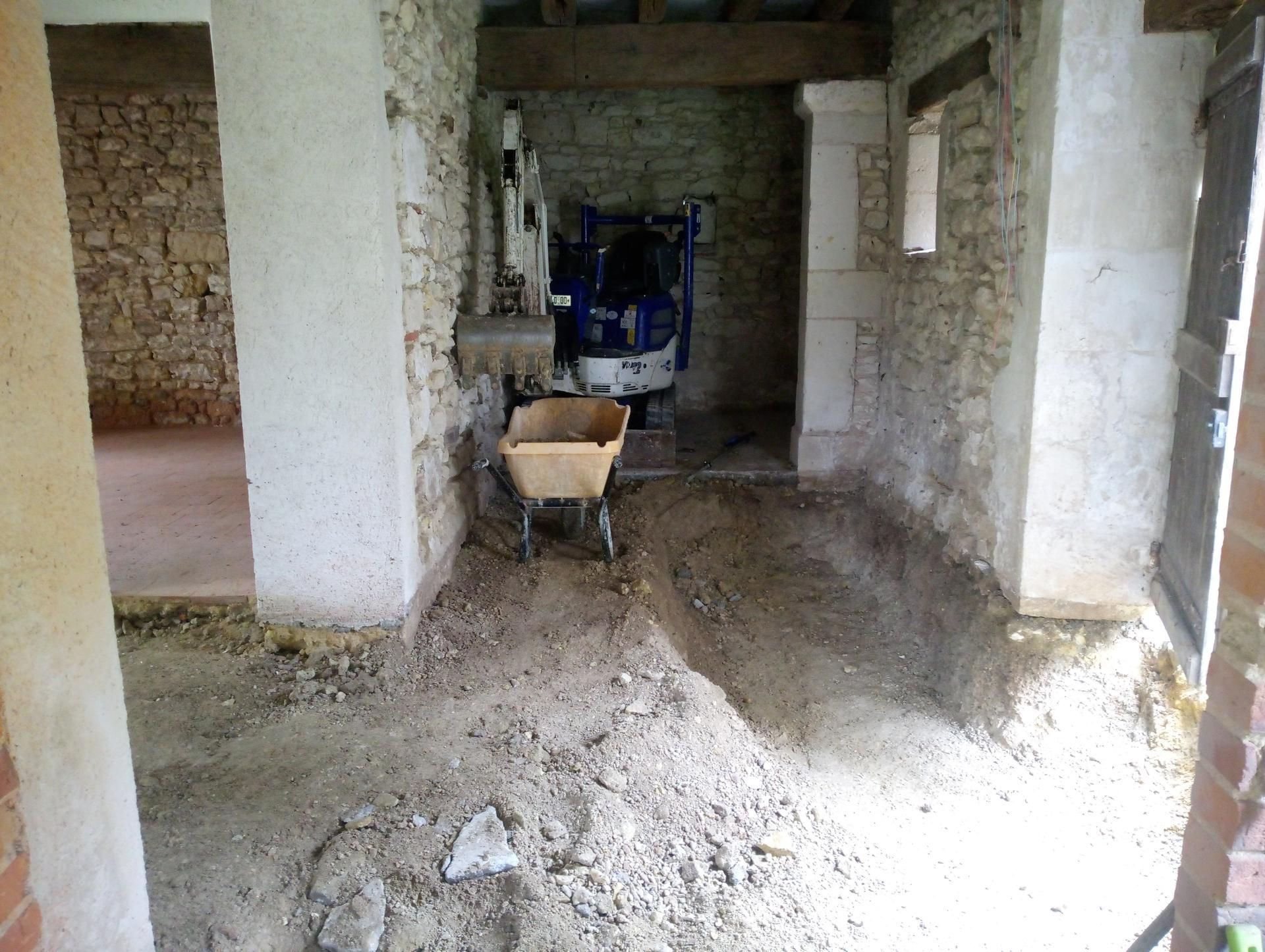 Rénovation intérieure : Sol et équipements dans un bâtiment en pierre.