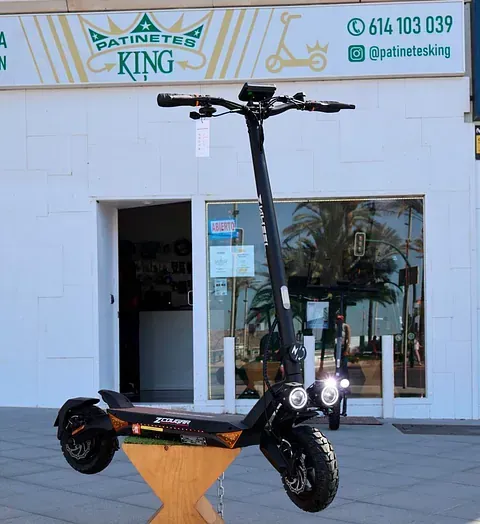Un scooter está estacionado frente a un edificio que dice rey
