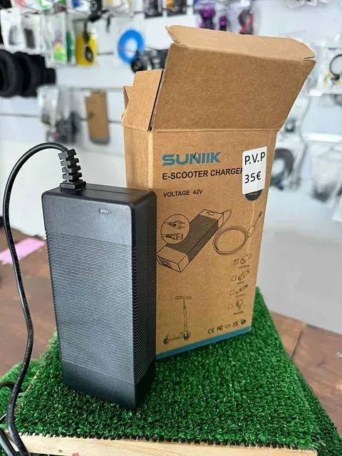 Un cargador está junto a una caja sobre una mesa.