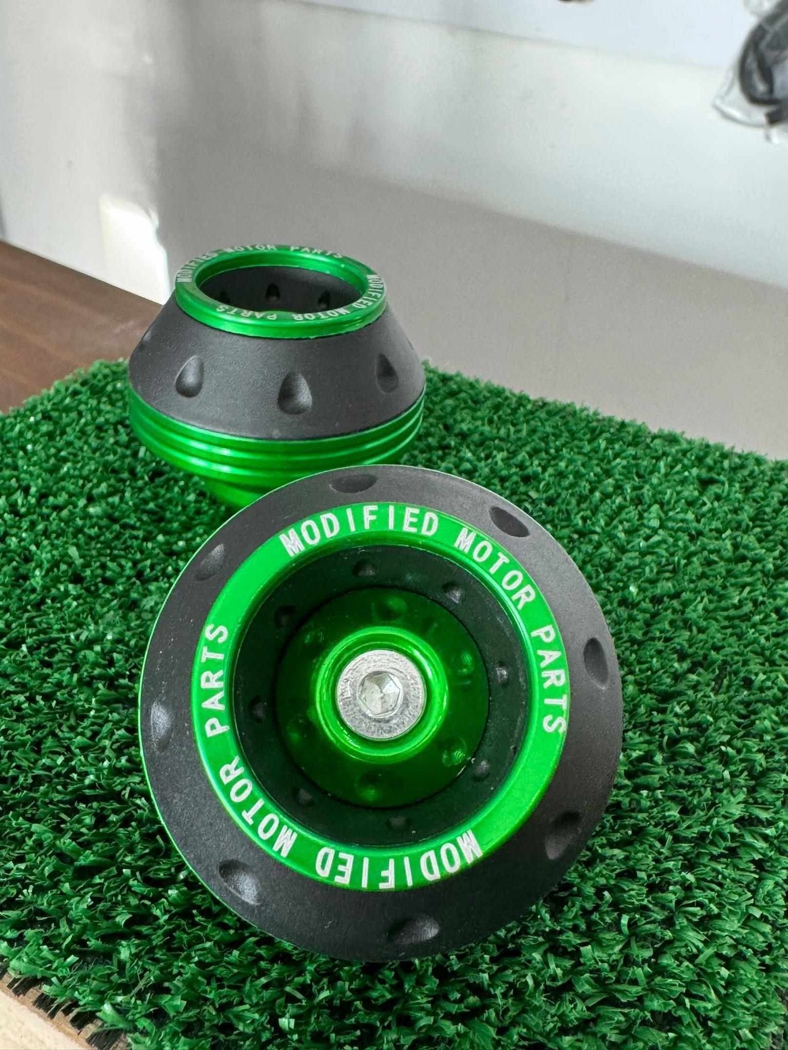 Un par de ruedas verdes y negras están colocadas sobre una alfombra verde.