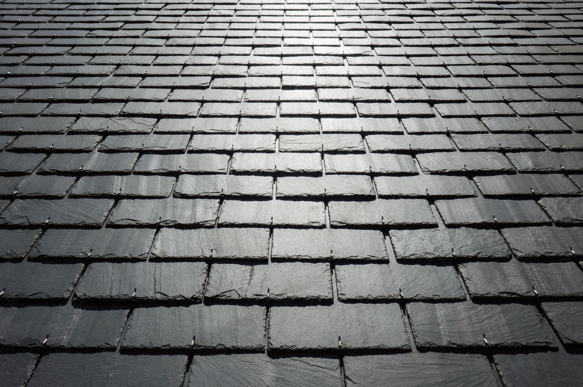 Tuiles en ardoise gris foncé, vue en perspective.