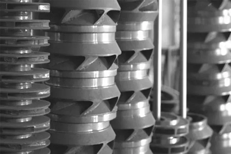 Una fotografía en blanco y negro de una pila de piezas de metal.