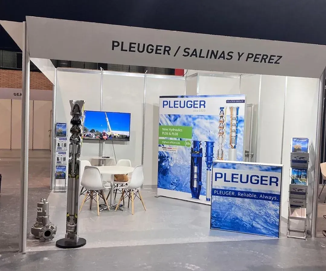 Un stand de Pleuger/Salinas y Pérez con mesa y sillas.
