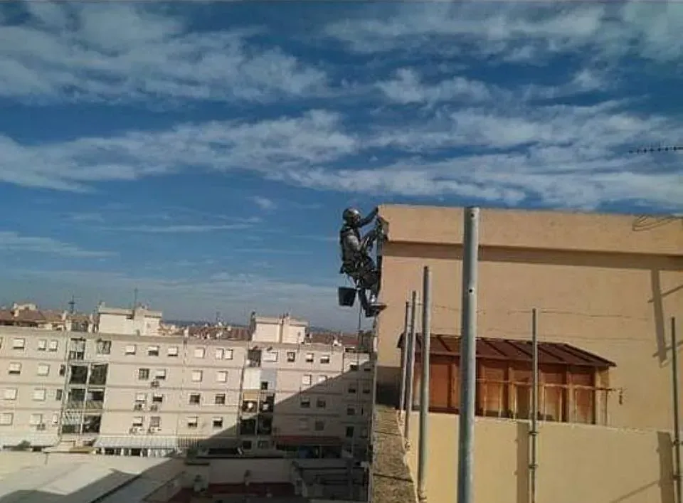 Un hombre está subiendo por el costado de un edificio.