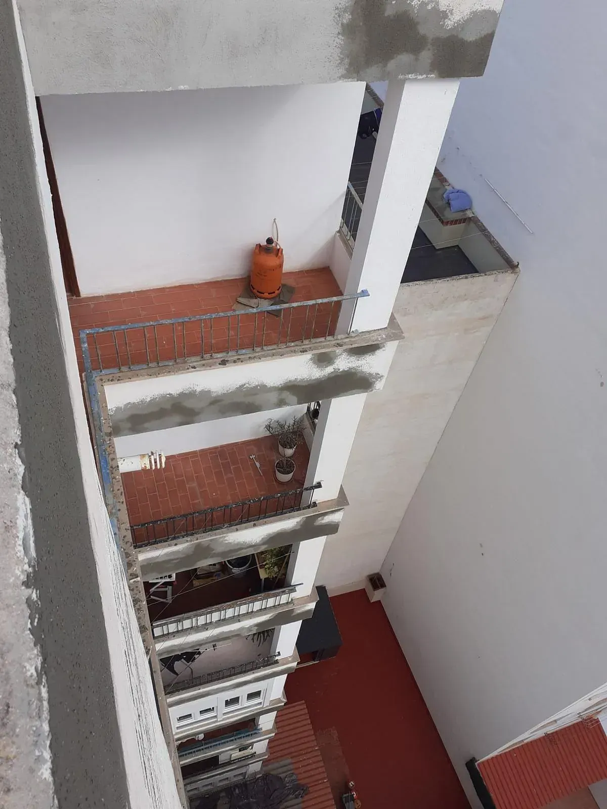 Una vista aérea de un edificio con un cilindro de gas en el balcón.