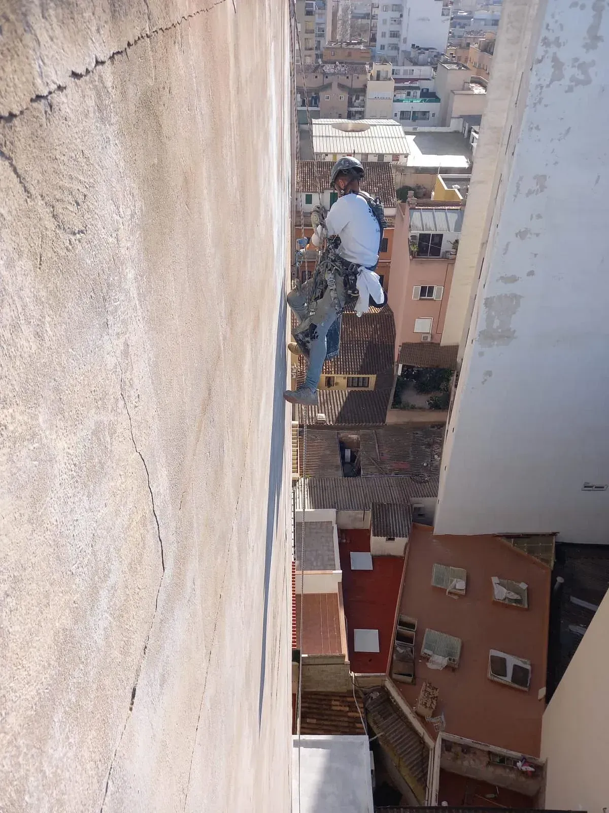 Un hombre está escalando una pared en una ciudad.