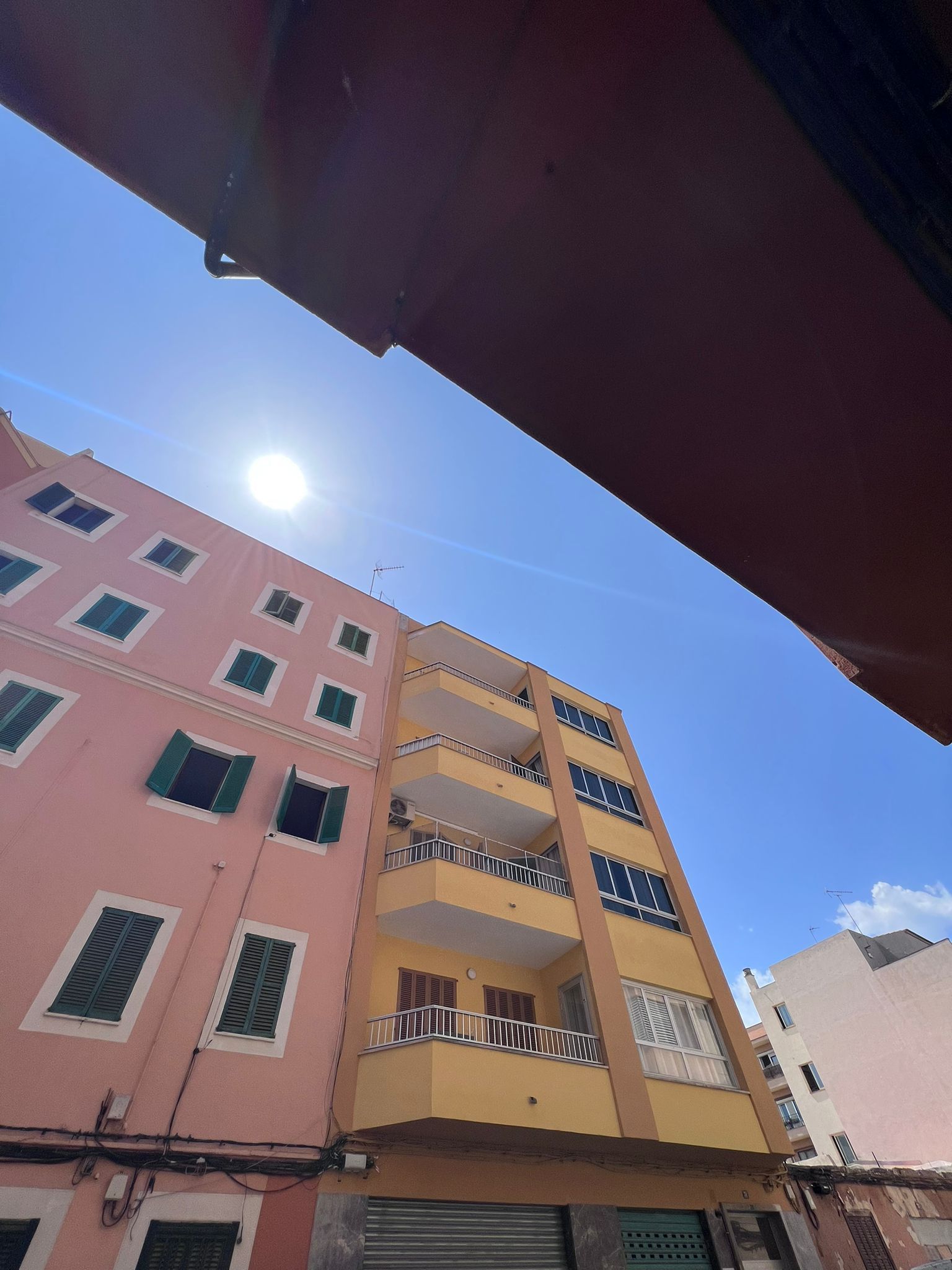 Mirando hacia arriba a un edificio con el sol brillando a través de las ventanas