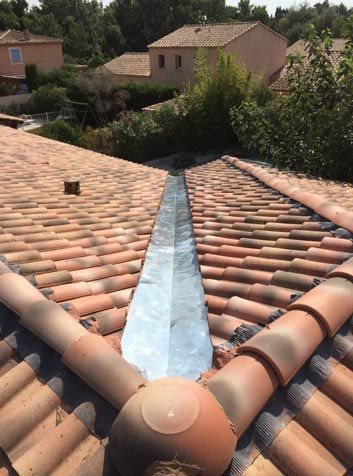 Le toit d'une maison avec un drain qui le traverse.