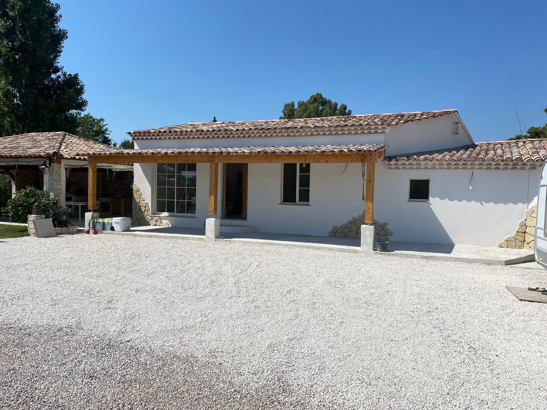 Une maison blanche avec une allée de gravier devant elle