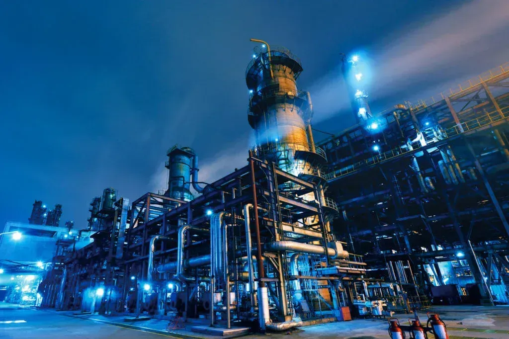 Una gran planta industrial está iluminada por la noche.