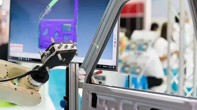Un robot está trabajando en la puerta de un coche en una fábrica.