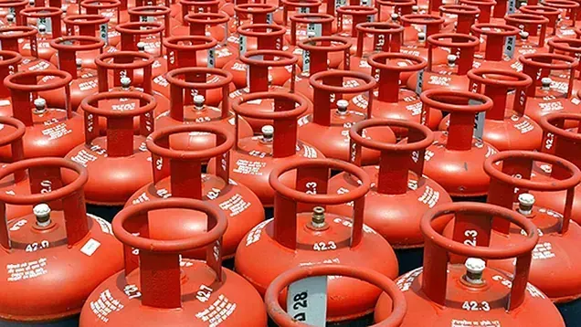 Un montón de cilindros de gas rojos están apilados uno encima del otro.