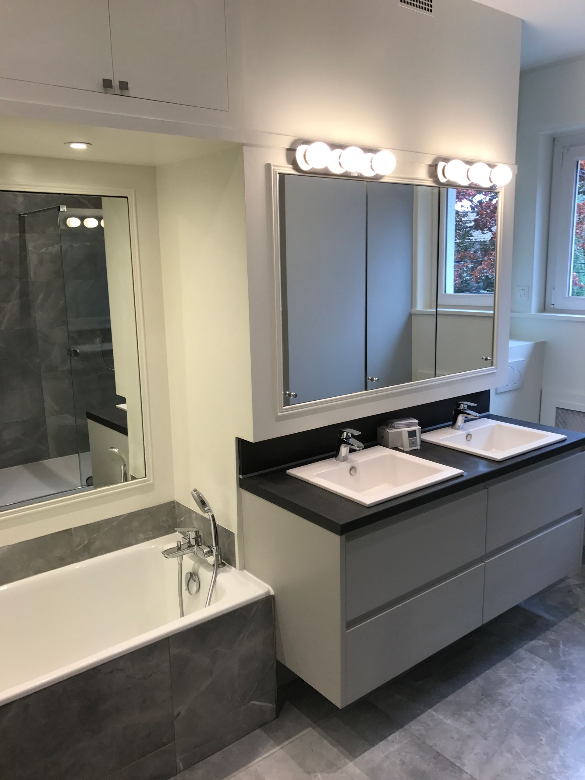 Salle de bains noire et blanche avec évier double vasque